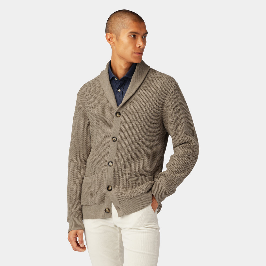 Model wearing the Taupe Cotton Cardigan layered over a dark shirt and paired with light jeans.